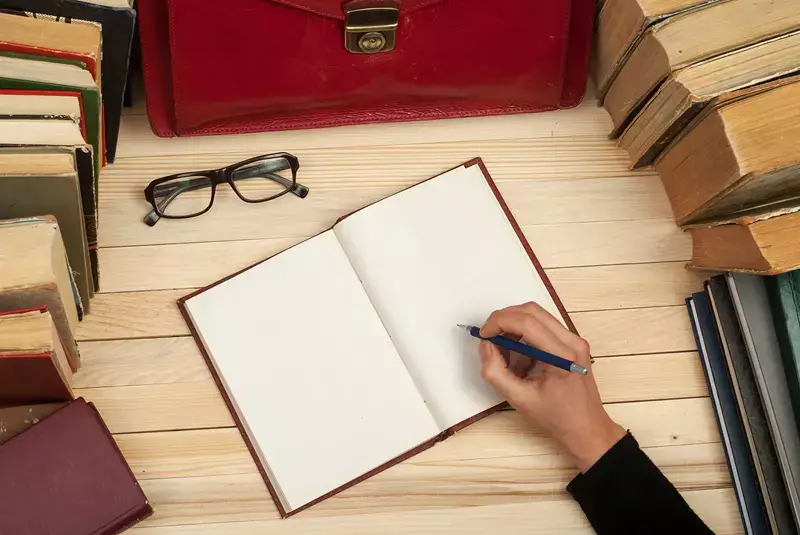 main qui écrit dans un cahier