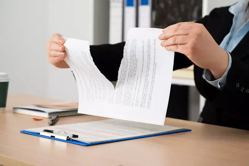 mains qui déchire un papier